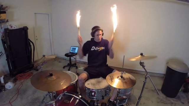Il joue Burn d'Ellie Goulding avec des baguettes en feu à la batterie