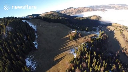 Amazing POV footage of man paragliding over fog