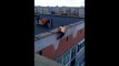 Le gars se suspend dans le vide au sommet d'un immeuble et fait des tractions