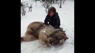 Elle fait un câlin à un gros nounours dans la neige, c'est adorable.