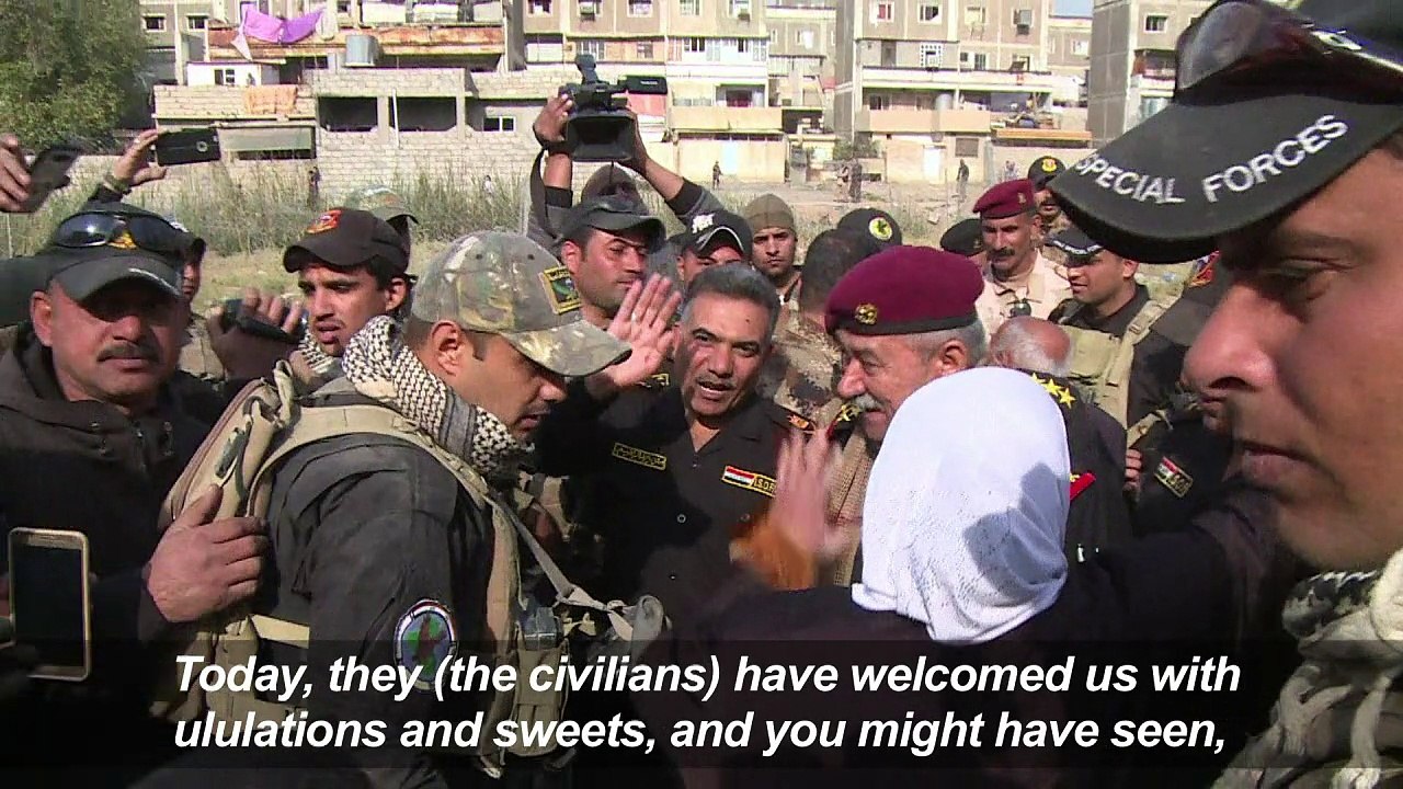 Iraqis in liberated Mosul district wave white f...