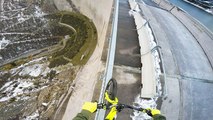 Il roule sur le bord d'un barrage très haut