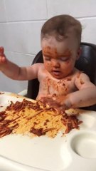 Un bebe essaie de rester éveillé pour manger ses spaghetti