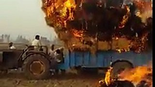 A Tractor with grass catches fire