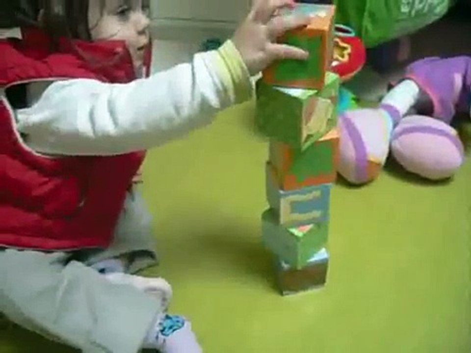 Un bébé de 18 mois joue avec des cubes- jeu dadresse et de construction