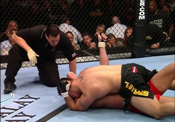 En mauvaise posture, un combattant MMA fait signe à l’arbitre pour qu’il n’arrête pas le combat