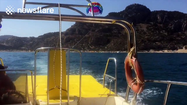 Woman hangs upside down metres above sea after parasailing accident