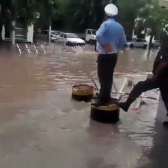 شرطي يسير حركة المرور من فوق برميل حديدي