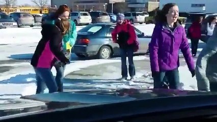 Un père se moque des enfants qui glissent sur le sol gelé devant lui