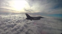 Cockpit view of F16 Fighting Falcon above a sea of clouds