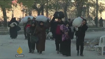 Syria’s war: Families escorted out of rebel-held areas in east Aleppo