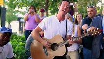 Some street musicians invite a homeless person to play