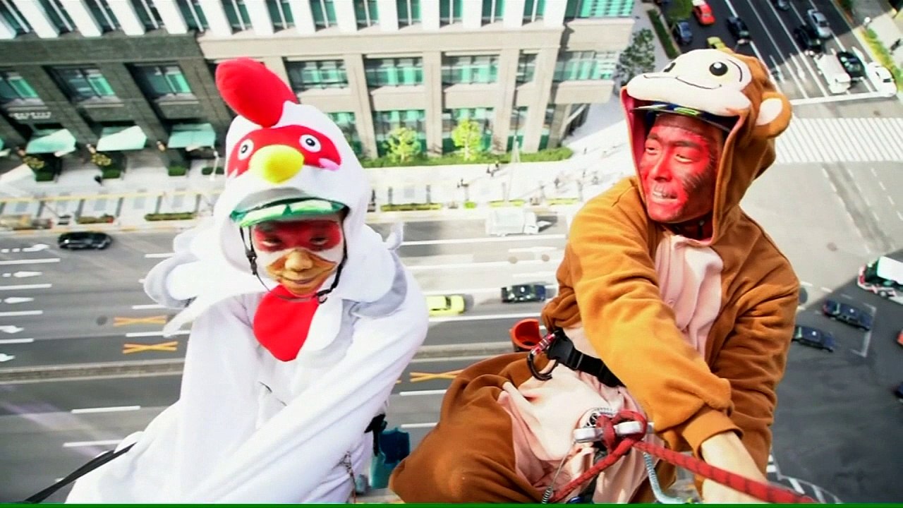 A monkey and a rooster clean windows in Tokyo