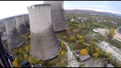 Paraglider drifts between huge chimneys in Romania industrial plant