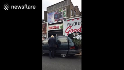 Boris Johnson struggles to fit large Christmas tree into his car
