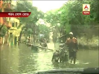 Pedestrians moving ahead throgh waterlogged Sarat Bose Road.