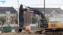 Deere 270D Excavator loading a big rig side tipper with rocks and cement on a construction site