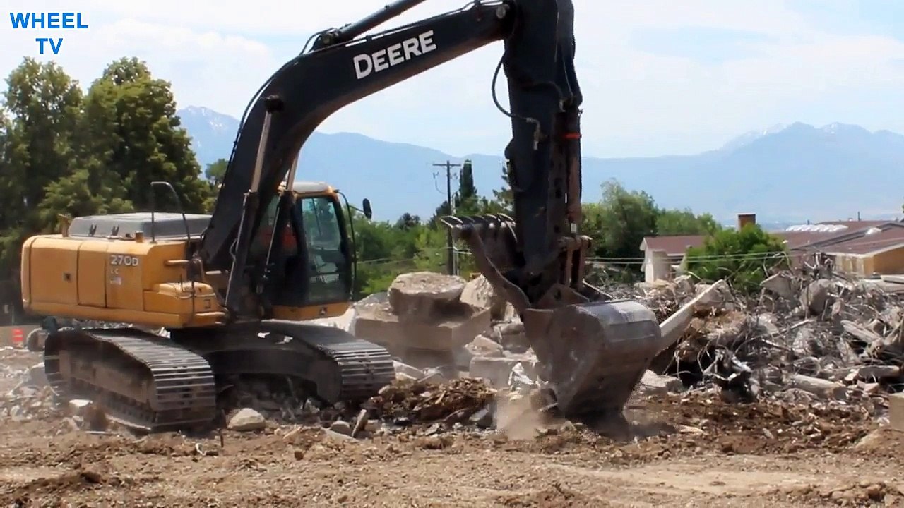 Deere 270D Excavator moving a concrete slab with rebar on a construction site
