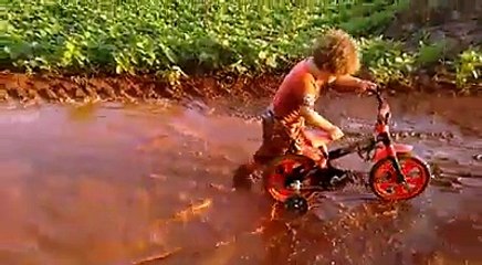 Un enfant s’amuse dans une énorme flaque de boue et c’est le meilleur moment de sa vie