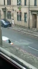 Deux hommes nus se battent en pleine rue