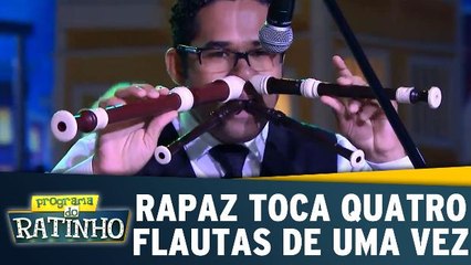 Rapaz toca quatro flautas de uma só vez