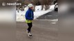 Boy ice-skates on frozen road in Ontario, Canada
