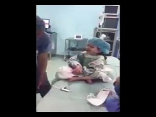 Küçük çocuğu güle eğlene ameliyata hazırlayan doktor