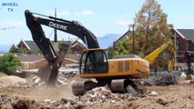 Deere 270D Excavator moving debris around from a demolished building before new construction