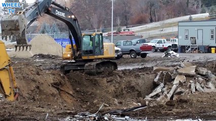 Deere 270D Excavator sifting dirt and rock to different piles on a huge work site