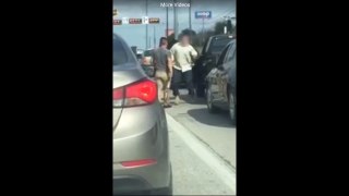 2 guys are fighting on the road