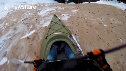 Group of friends go 'snow kayaking' down a hill