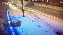 Car drifting on icy road narrowly avoids street pole and building