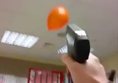 Un homme tire sur des ballons avec un pistolet à agrafe !