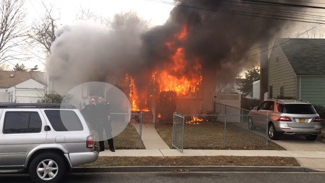 Police officers take selfie in front of burning house