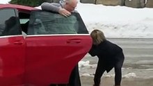 Une_jeune_femme_se_fait_aider_par_son_père_pour_grimper_dans_sa_voiture_stationn