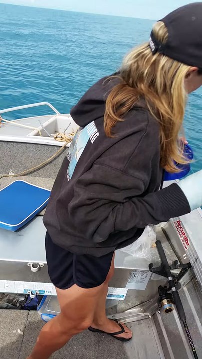 platrée d'un bras, elle pêche avec l'autre et attrape un gros poisson