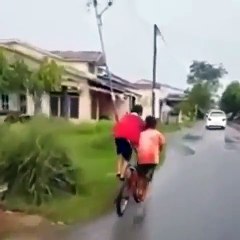 Two kids riding one bike