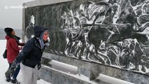 Women use snow to enhance embossed ancient Greek sculpture