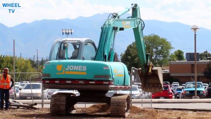 Blue Jones Excavator moving dirt next to a road, construction machine