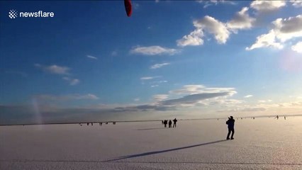 People go ice-kiting on frozen lake Neusiedl