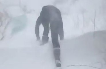 Une femme tente de rejoindre sa voiture pendant une tempête de neige !