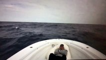 Un homme allongé sur un bateau se prend une grosse vague !