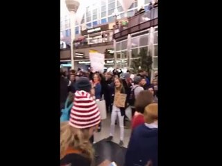 People praying At Dallas Airport during protest against Trump