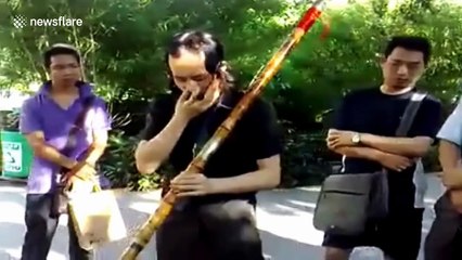 Artist plays music on gigantic flute