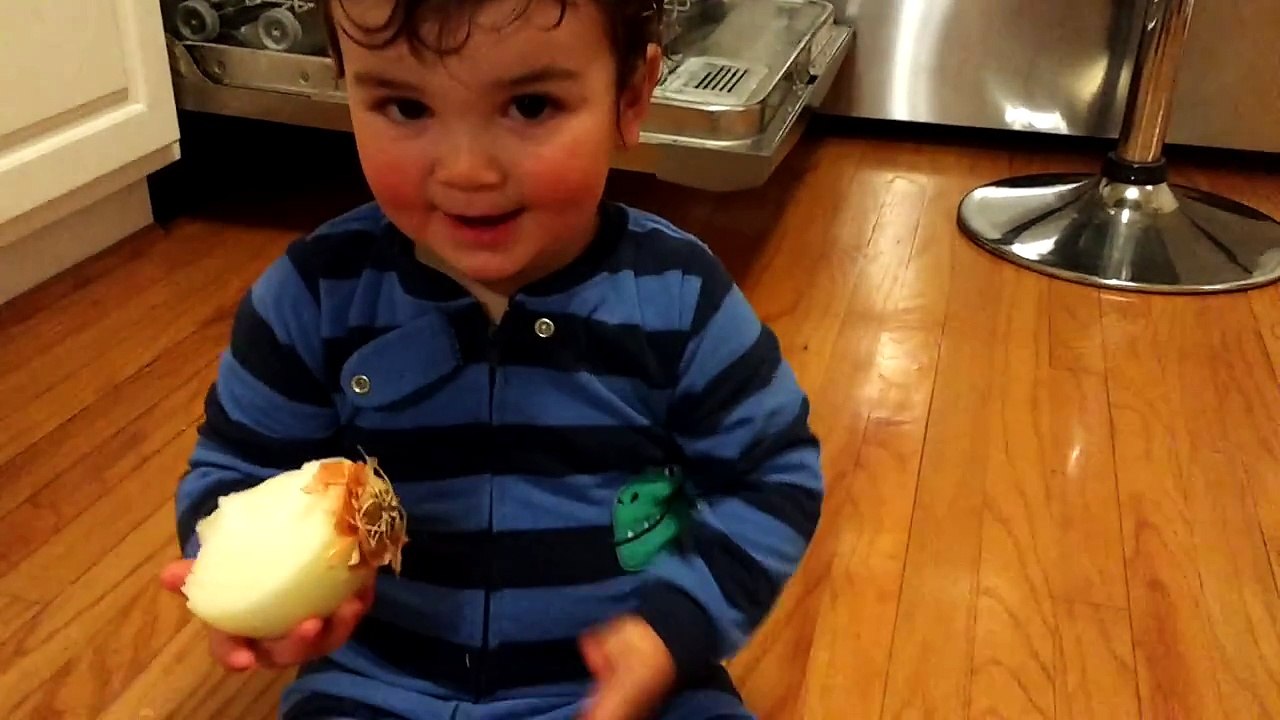 Ce bébé goute un oignon en croquant dedans ! Courageux!