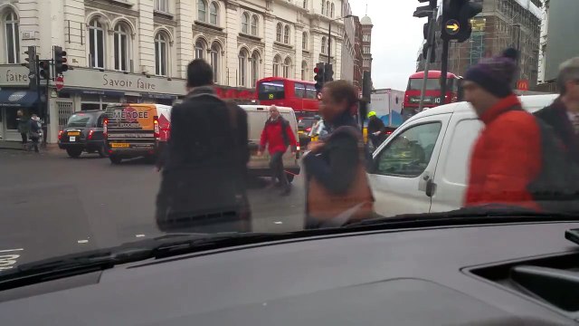 Des piétons pas attentifs ne voient pas une corde de remorquage entre deux voitures