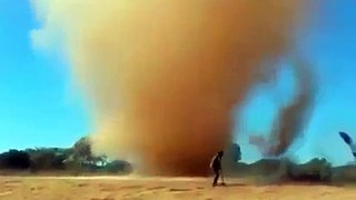 Brasileiros jogando areia no tornado
