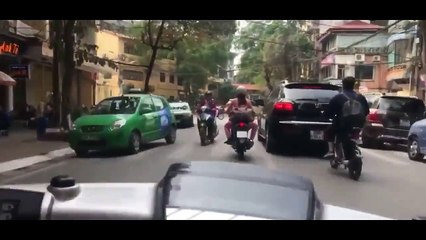 Une femme en scooter roule comme une malade dans les rue en Thaïlande.