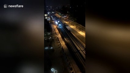 Sparks appear as train rolls on snow-covered track