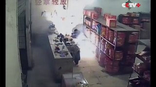 Un homme allume des pétards devant une boutique de feux d'artifice